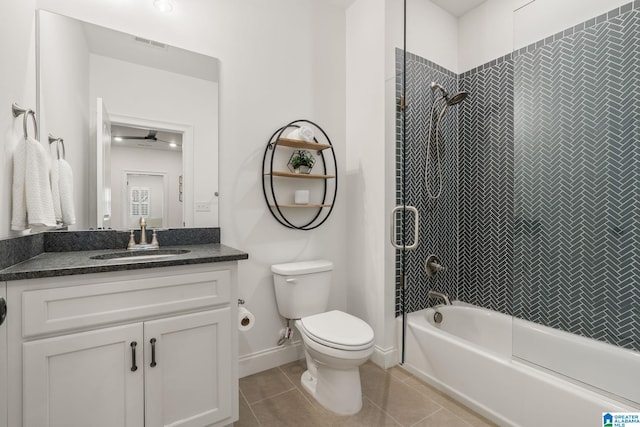 full bathroom featuring vanity, tiled shower / bath combo, tile patterned floors, and toilet