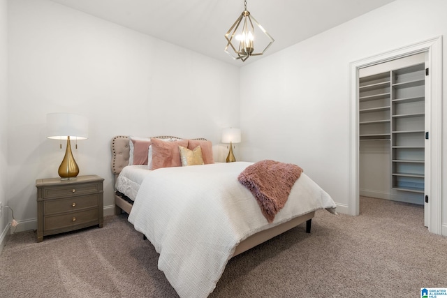 bedroom featuring a walk in closet, carpet, a chandelier, and a closet