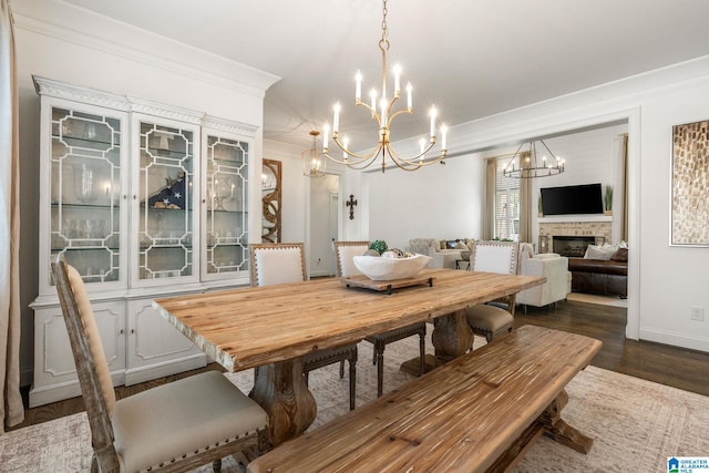 dining area featuring a notable chandelier, dark wood-type flooring, and ornamental molding