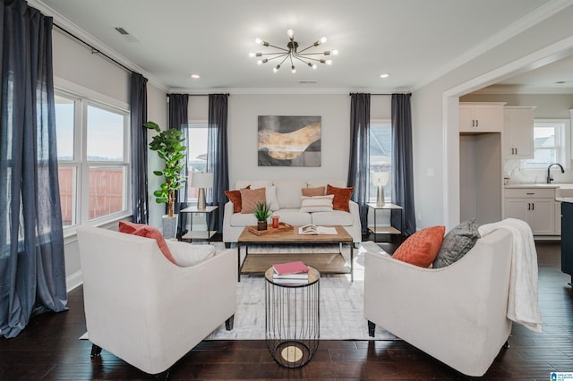 living room featuring ornamental molding, sink, a chandelier, and dark hardwood / wood-style flooring