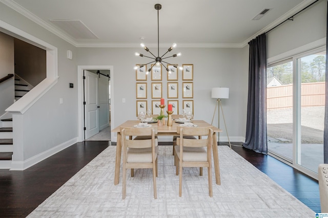 dining space with dark hardwood / wood-style floors, ornamental molding, and a barn door