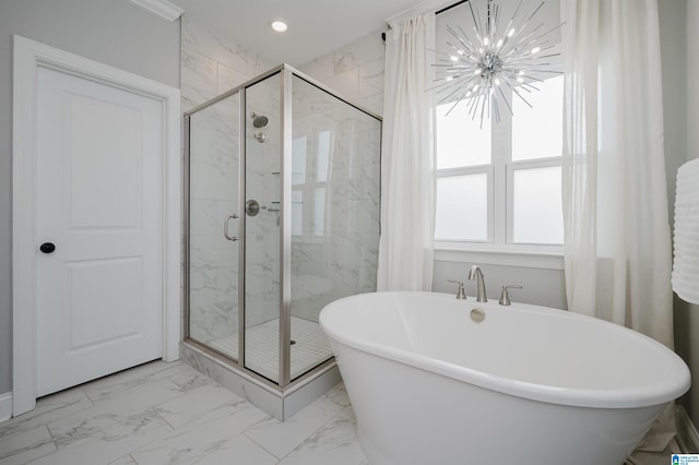 bathroom with an inviting chandelier and shower with separate bathtub