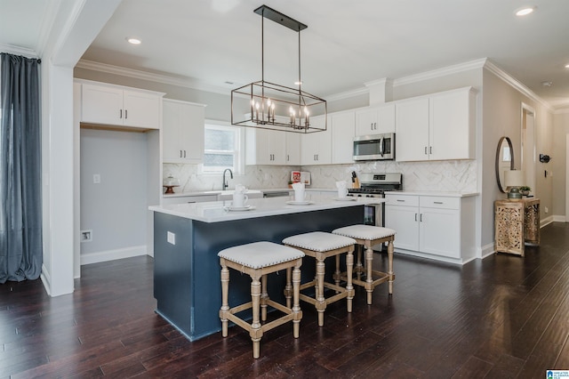 kitchen with a kitchen island, white cabinets, and appliances with stainless steel finishes