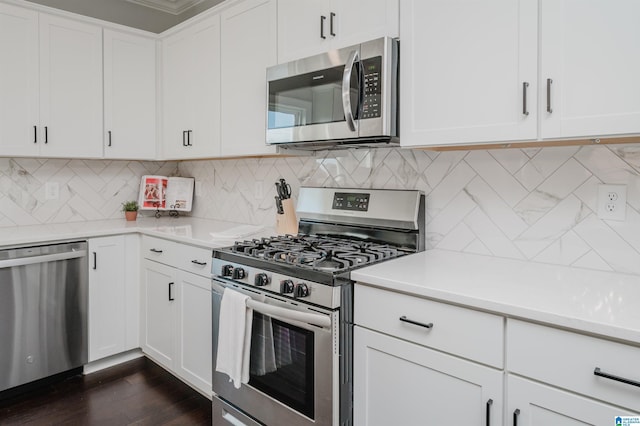 kitchen with tasteful backsplash, appliances with stainless steel finishes, dark wood-type flooring, and white cabinets