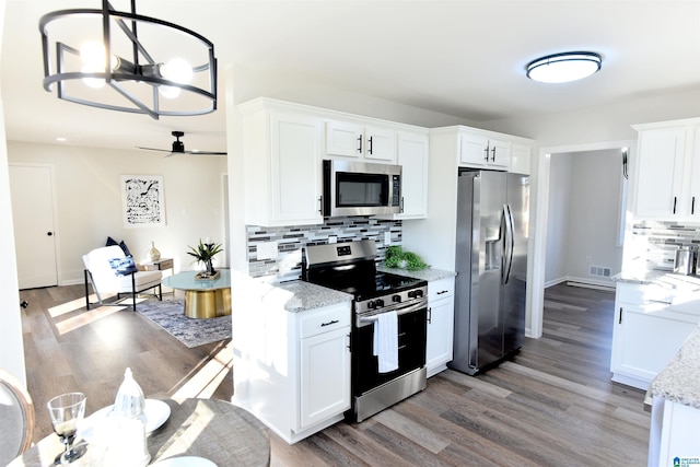 kitchen with hanging light fixtures, white cabinetry, appliances with stainless steel finishes, and light stone countertops