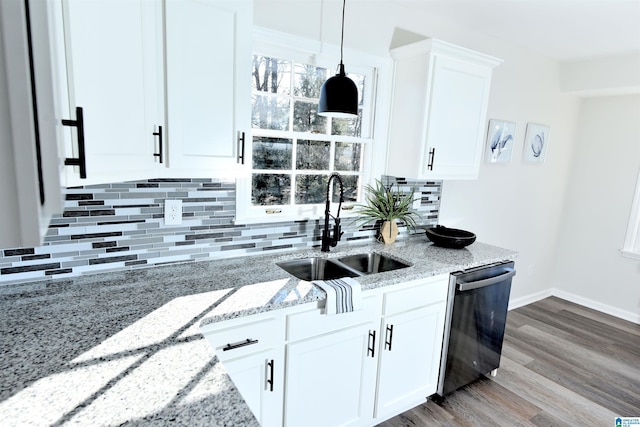 kitchen featuring sink, white cabinetry, light stone counters, decorative light fixtures, and stainless steel dishwasher