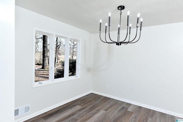 unfurnished dining area with an inviting chandelier and dark wood-type flooring