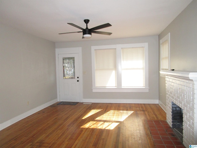 unfurnished living room with hardwood / wood-style flooring, ceiling fan, and a fireplace