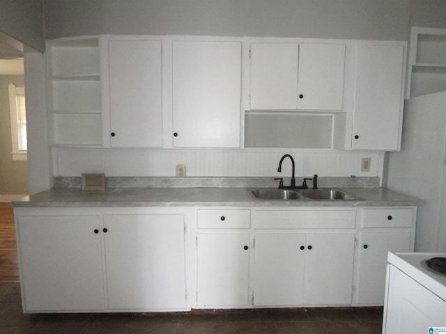 kitchen with electric range, sink, and white cabinets