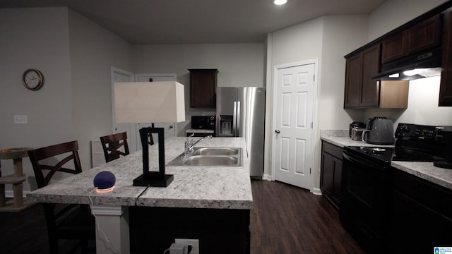 kitchen with sink, a breakfast bar area, a kitchen island with sink, electric range, and stainless steel refrigerator with ice dispenser