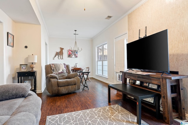 living room with crown molding, dark wood-type flooring, and a notable chandelier