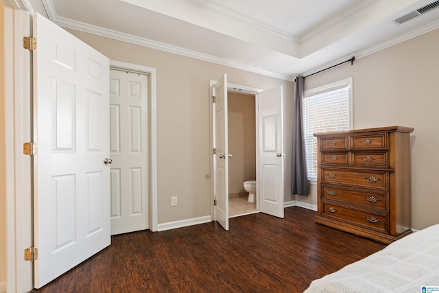 unfurnished bedroom featuring a tray ceiling, dark wood-type flooring, and ornamental molding