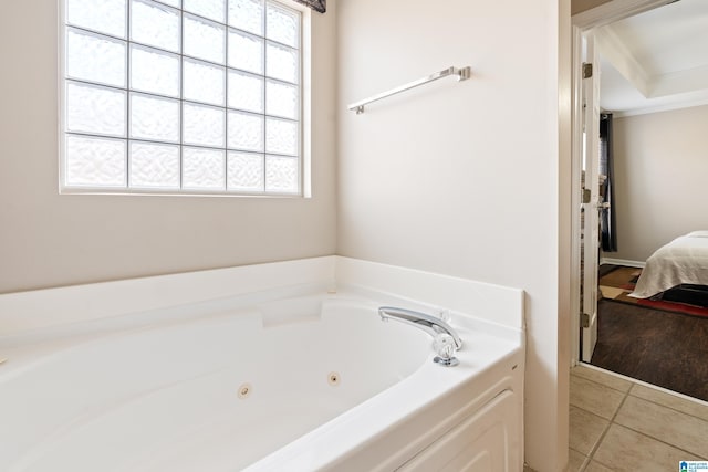 bathroom with a tub to relax in, crown molding, and tile patterned floors