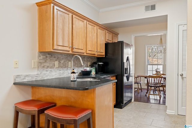 kitchen with a breakfast bar, sink, backsplash, ornamental molding, and kitchen peninsula