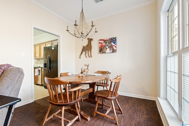 dining room with dark wood-type flooring, ornamental molding, and a chandelier