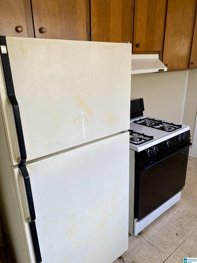 kitchen with white fridge and gas range oven