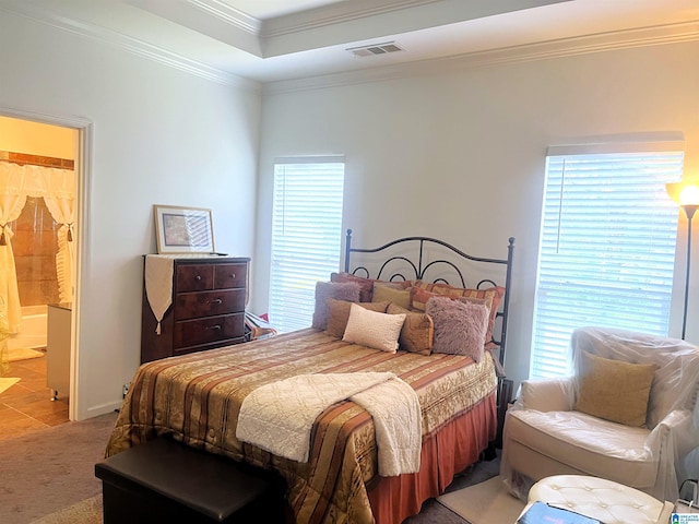 bedroom featuring crown molding, connected bathroom, a raised ceiling, and carpet floors