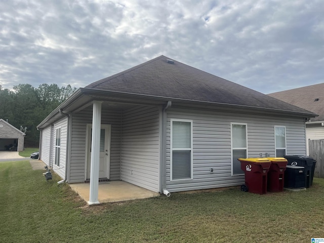 back of house with a patio area and a lawn