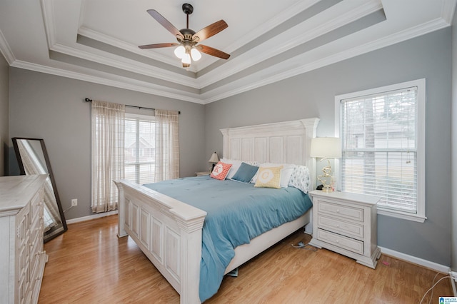 bedroom featuring ornamental molding, a tray ceiling, and light hardwood / wood-style flooring