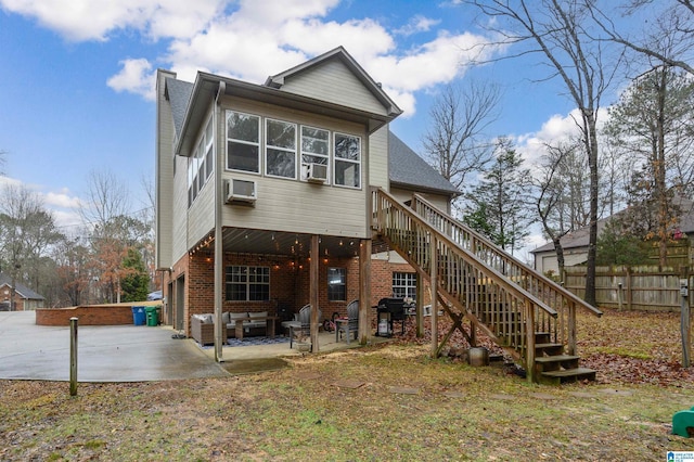 rear view of house with a garage, a wall mounted AC, and a patio