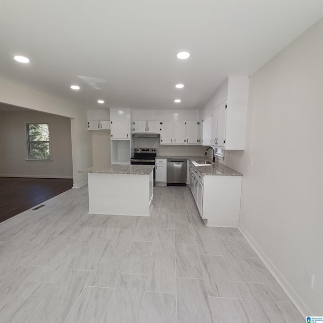 kitchen with white cabinetry, stainless steel dishwasher, light stone countertops, and sink