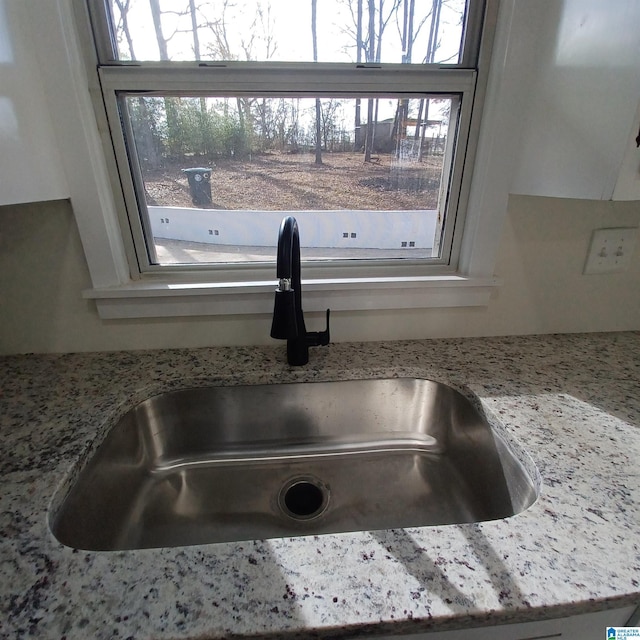 room details featuring light stone counters and sink