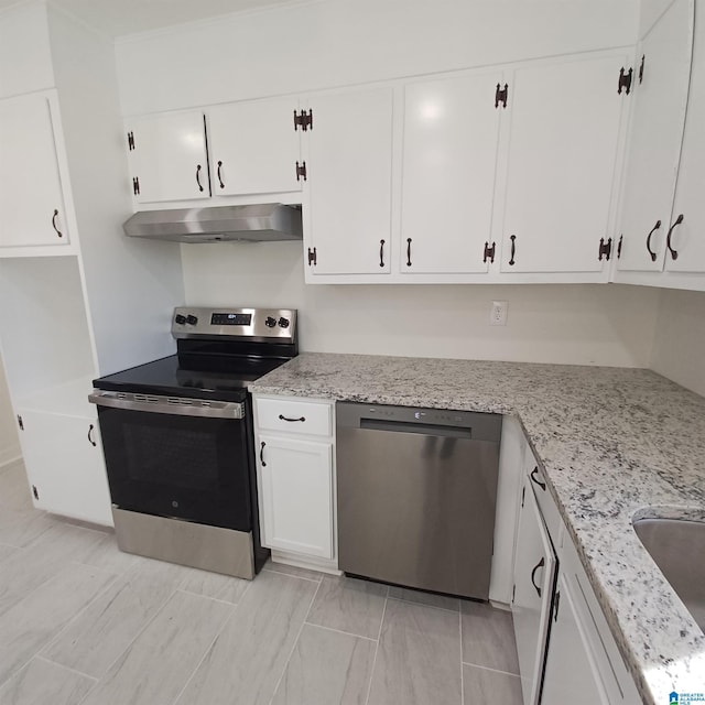 kitchen with light stone countertops, white cabinetry, and appliances with stainless steel finishes