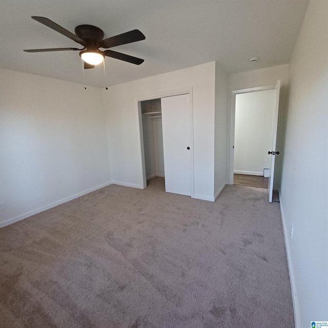 unfurnished bedroom with ceiling fan, a closet, and light carpet