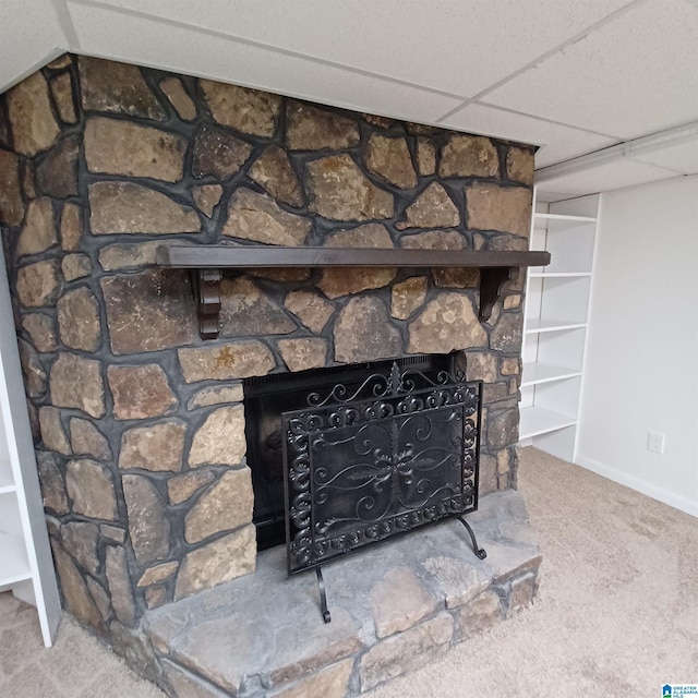 room details featuring carpet flooring, a paneled ceiling, and a fireplace