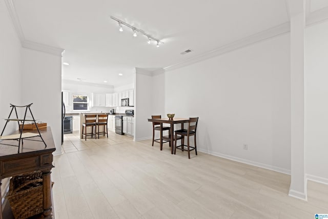 dining room featuring crown molding and light hardwood / wood-style flooring