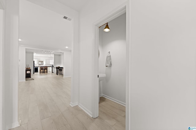 corridor with light wood-type flooring