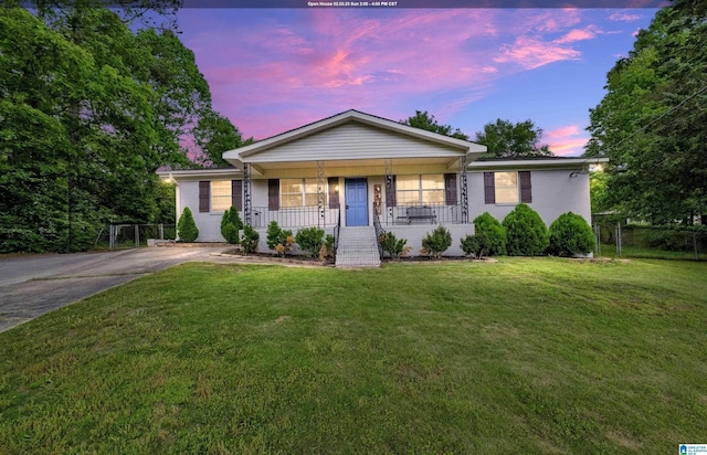 single story home featuring a yard and covered porch