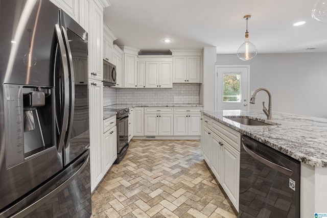 kitchen with tasteful backsplash, sink, white cabinets, hanging light fixtures, and black appliances