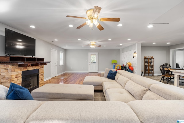 living room featuring a stone fireplace and hardwood / wood-style floors