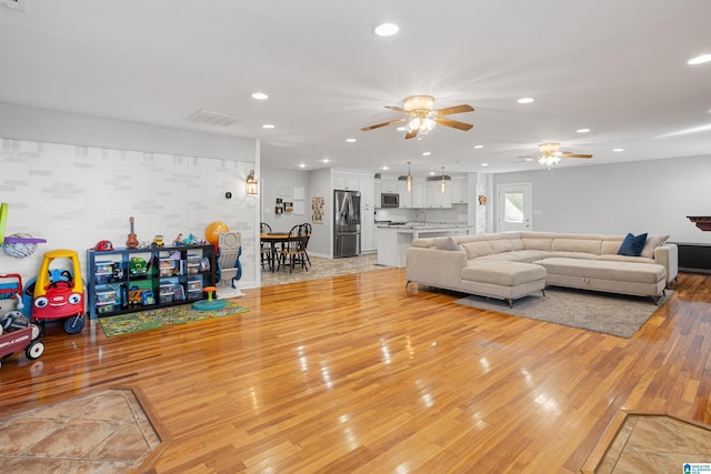 living room with sink and light wood-type flooring