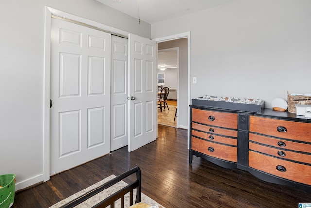 bedroom with dark hardwood / wood-style flooring and a closet