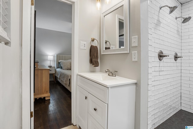 bathroom featuring tiled shower, vanity, and wood-type flooring