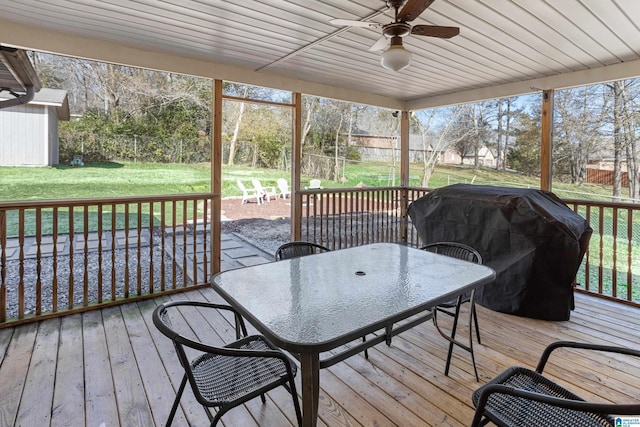 deck with grilling area, a yard, and ceiling fan