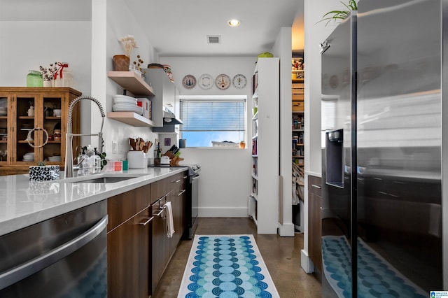 kitchen featuring light stone counters, appliances with stainless steel finishes, and sink