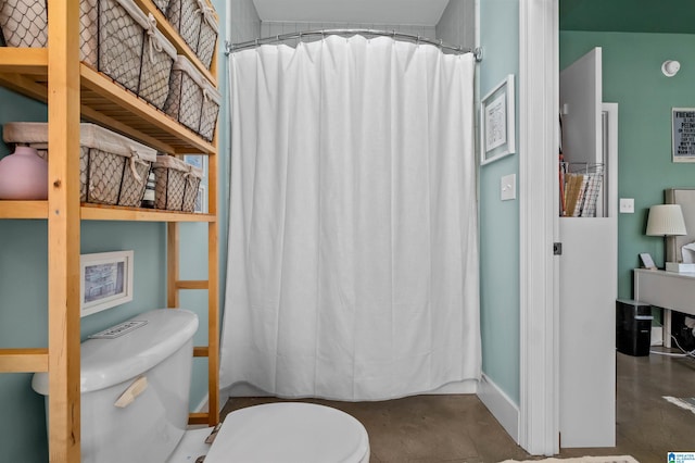 bathroom featuring concrete flooring, walk in shower, and toilet