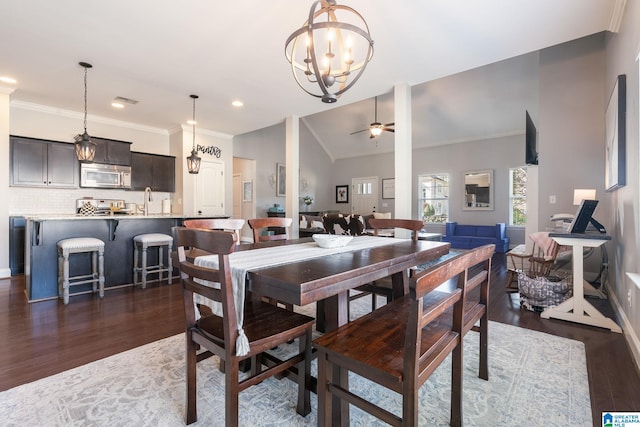 dining area with lofted ceiling, sink, ceiling fan, crown molding, and dark wood-type flooring