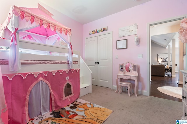 bedroom featuring vaulted ceiling, a closet, and carpet