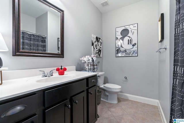 bathroom featuring tile patterned flooring, vanity, and toilet