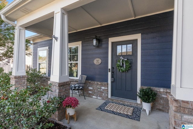 view of exterior entry featuring covered porch