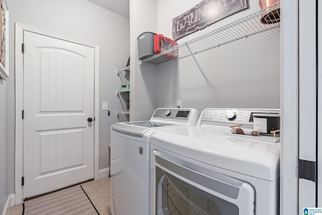 clothes washing area with light tile patterned floors and independent washer and dryer