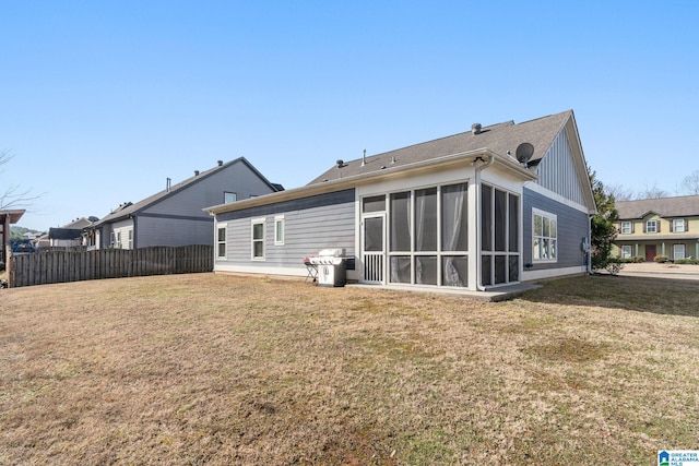 back of house with a sunroom and a lawn