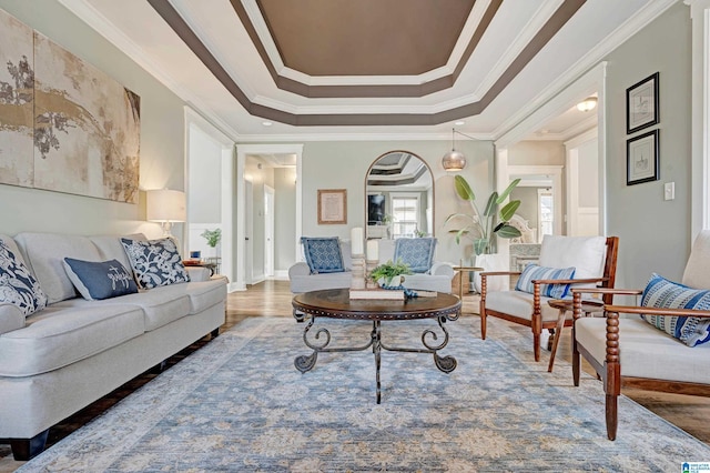 interior space featuring crown molding, wood-type flooring, and a tray ceiling