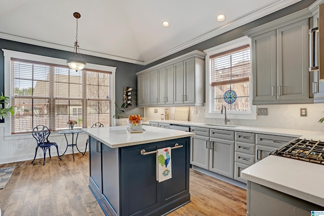 kitchen featuring vaulted ceiling, sink, gray cabinetry, hanging light fixtures, and crown molding