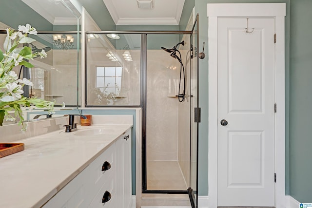 bathroom with vanity, a shower with shower door, and ornamental molding