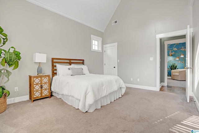 carpeted bedroom with ornamental molding and high vaulted ceiling